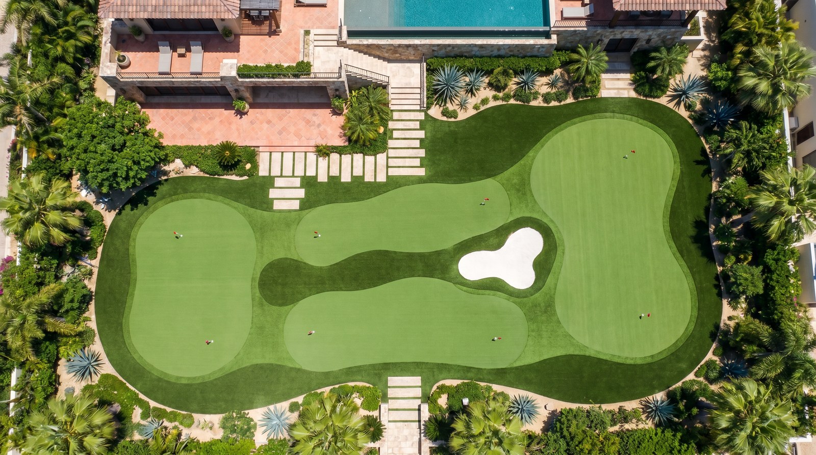 Putting green con superficie de césped corto, hoyo, cup y bandera donde se practica el putt en golf